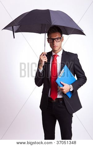 young business man holding an umbrella and ra blue notepad