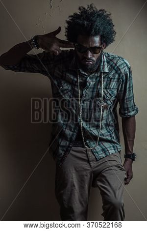 Afroamerikaner In A Checkered Shirt Holds His Fingers To His Temple Imitating A Gun