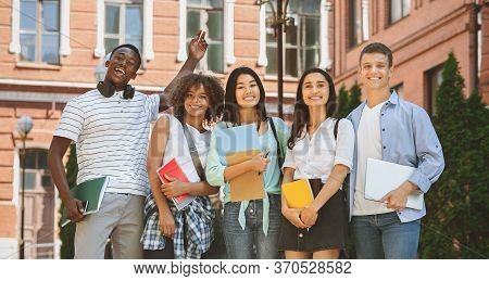 Freshmen Orientation Concept. Group Of First Year Students With Workbooks Posing Together Outdoors, 