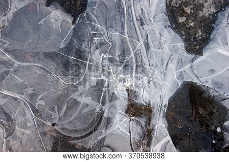 Frozen Puddle With Broken Ice. Winter Season.