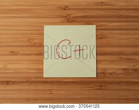 Sticker Depicting The Letter C. Paper Sticker Pasted On A Wooden Surface. Self-adhesive Paper Sheet.