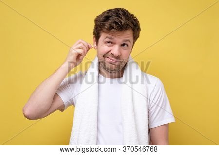 Man About To Clean His Ears Using Cotton Swab. Hygiene Essentials Concept.