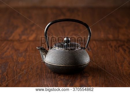 Black Japanese Cast-iron Teapot On A Dark Wooden Background, Horizontal