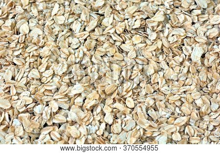 Pile Of Oat-flakes, Background Of Uncooked Oats. Texture Of Raw Oatmeal. Diet Food Concept