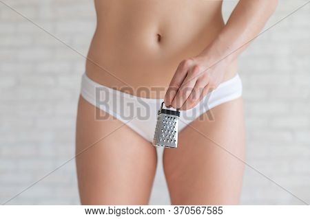 Unrecognizable Woman In White Panties Holds In Hands A Mini Grater. Metaphor Of The Bristles After D