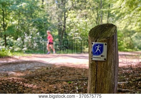 Borger,the Netherlands-may 18,2020:nordic Walking Hiking Trail Sign Along Side An Old Natural Stone 