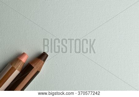 Two Pink And Brown Colored Pencils Peeking Out Of The Corner
