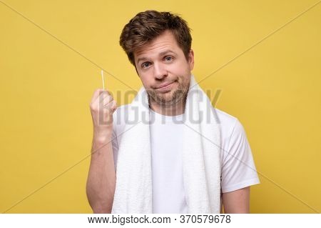 Man About To Clean His Ears Using Cotton Swab. Hygiene Essentials Concept.
