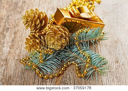 Golden Weihnachtsschmuck auf Kiefer Zweig hölzernen Hintergrund