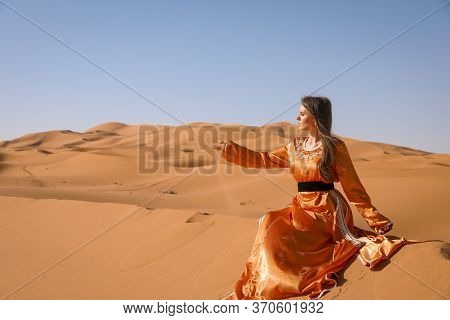 Beautiful Young Girl In Moroccan Dress In Sahara Desert.