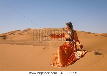 Beautiful Young Girl In Moroccan Dress In Sahara Desert.