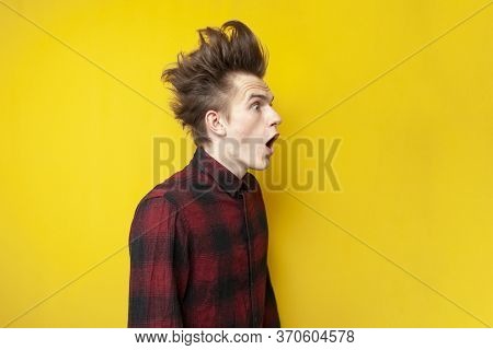 Young Shocked Guy Surprised At Yellow Isolated Background, Hipster With Funny Hairstyle Screaming To