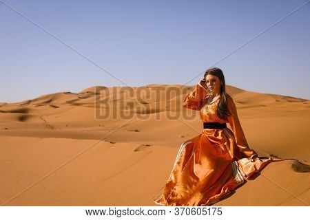Beautiful Young Girl In Moroccan Dress In Sahara Desert.