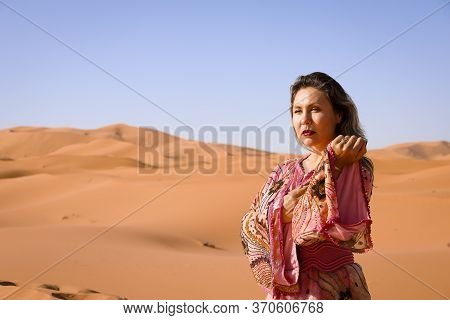 Girl In Moroccan Dress In Sahara Desert.