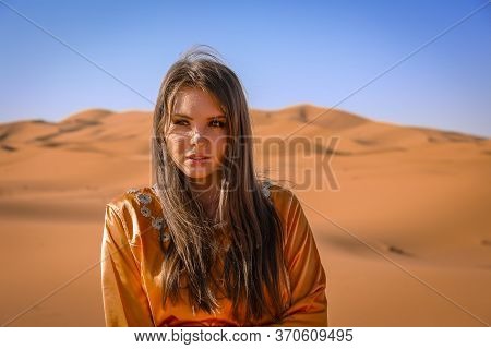 Beautiful Young Girl In Moroccan Dress In Sahara Desert.