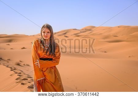 Beautiful Young Girl In Moroccan Dress In Sahara Desert.