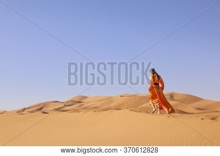 Beautiful Young Girl In Moroccan Dress In Sahara Desert.