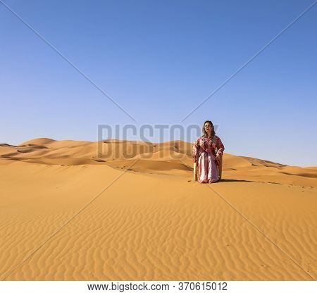 Girl In Moroccan Dress In Sahara Desert.