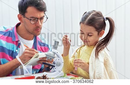 Smiling Cute Little Girl Doing Science Experiments In The Laboratory Together With Father Who Makes 