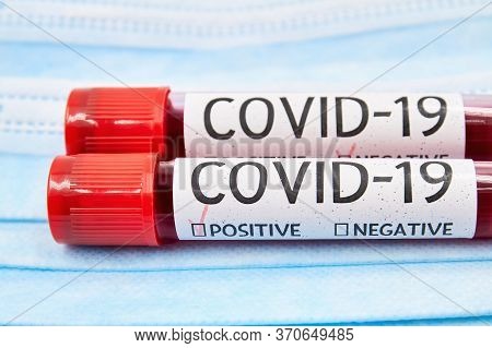 Conceptual Photo. Blood Test Samples For Presence Of Coronavirus On The Face Protective Madical Mask