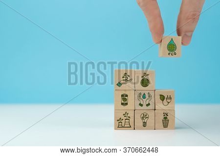 Wooden Blocks With Environmental Symbols Arranged A Man Is Holding The Top One. Ecology