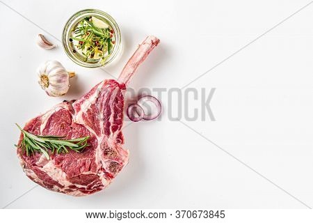 Cooking Meat Background. Raw Tomahawk Steak, With Spices And Herbs For Cooking On White Table Backgr