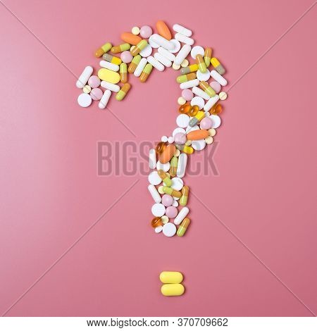 Close Up Of Many Different Pills In Question Mark Sign Form On Pink Background.