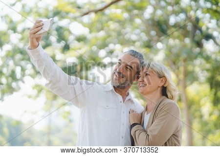 Technology Connect And Modern Elderly Lifestyles Concept. Aged Senior Couple Waving Hands Greeting G