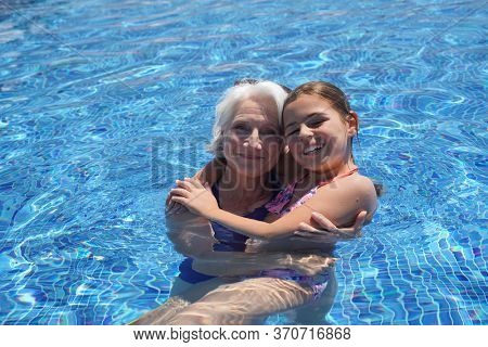 Grandmother with grandkid in resort swimming-pool