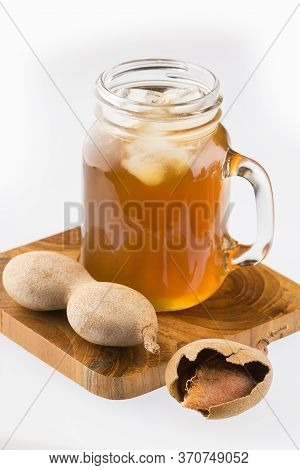 Tamarind Juice In A Glass Surrounded By Fresh Ripe Tamarinds - Tamarindus Indica