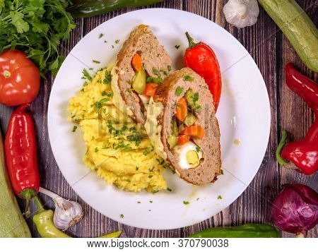 Delicious Stuffed Meatloaf Slices With Egg And Vegetables Garnish With Mashed Potatoes. Top View