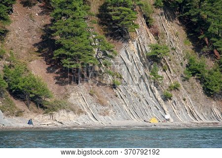 Steep, Rocky Shore Of The Sea With Trees Growing On A Slope Not Far Of The City Of Dzhubga At The Bl
