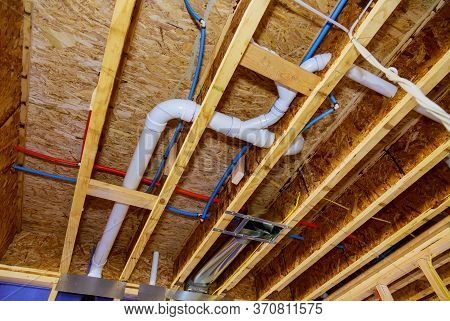 Home Construction With Hot Red And Cold Blue Pex Pipe Layout In Pipes And Exposed Beams