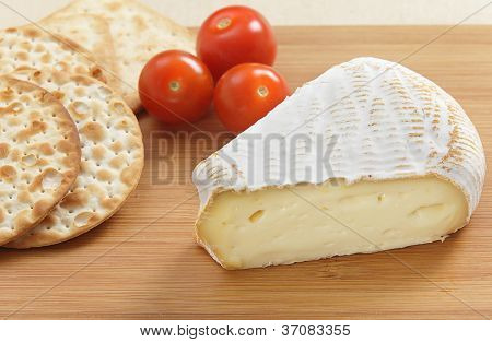 Ein Keil aus St Albray Käse mit Cracker und Cherry-Tomaten auf einer Käseplatte