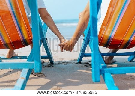 Couple Sitting On The Deck Chairs At The Beach. Honymoon, Love, Travel Or Vacation Concept.