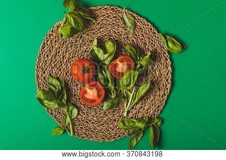 Basil And Tomatoes On A Palm Petate With A Green Background