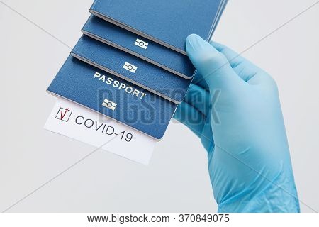 Immunity Passport, Risk-free Certificate Concept. Hand In Medical Glove Hold Passports With Note Cov