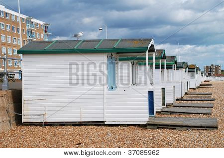 Træ beach huts på stenstrand i Bexhill-on-Sea i East Sussex, England.