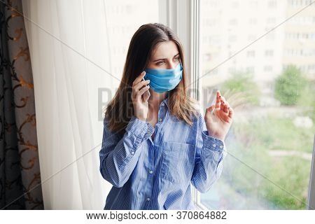 Young Beautiful Woman In Medical Mask Talking On Phone. Coronavirus. Concept Home Quarantine, Isolat