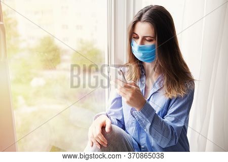 Young Beautiful Woman In Medical Mask Talking On Phone. Coronavirus. Concept Home Quarantine, Isolat