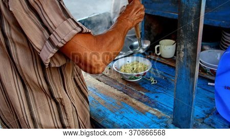 Indonesian Food, Mie Ayam, Noodles With Chicken Presented Directly By The Seller On The Cart, Unfocu
