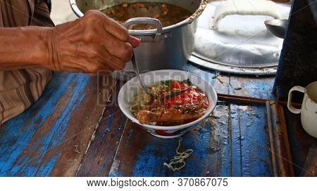 Indonesian Food, Mie Ayam, Noodles With Chicken Presented Directly By The Seller On The Cart, Unfocu