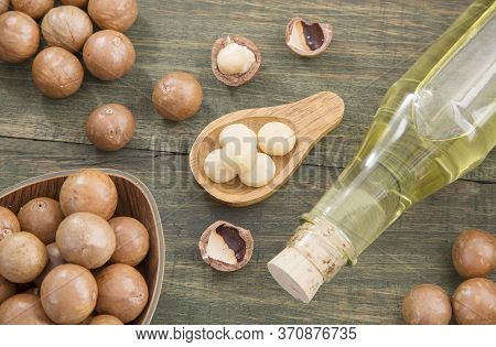 Nuts And Macadamia Oil On Wooden Background - Macadamia Integrifolia