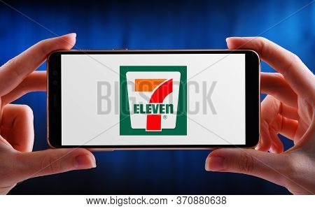 Poznan, Pol - May 21, 2020: Hands Holding Smartphone Displaying Logo Of 7-eleven Inc., International