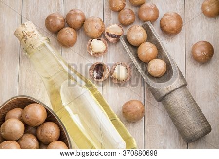 Nuts And Macadamia Oil On Wooden Background - Macadamia Integrifolia