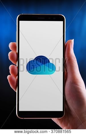 Poznan, Pol - May 21, 2020: Hands Holding Smartphone Displaying Logo Of Microsoft Onedrive, A File H