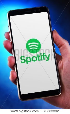 Hand Holding Smartphone Displaying Logo Of Spotify