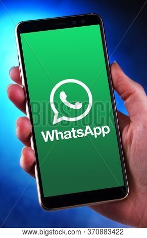 Hand Holding Smartphone Displaying Logo Of Whatsapp Messenger