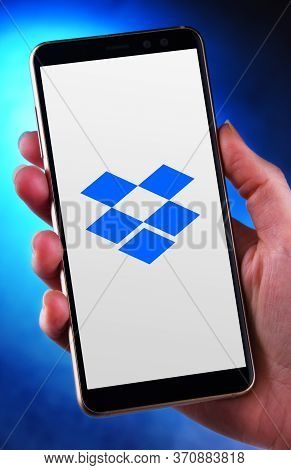 Hand Holding Smartphone Displaying Logo Of Dropbox