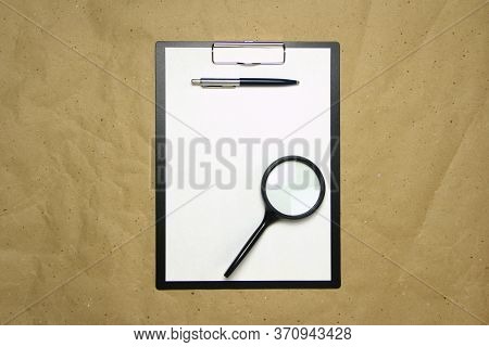 A Tablet With A White Sheet Of A4 Format With Magnifier, Pen And Magnifier On A Beige Craft Paper. C